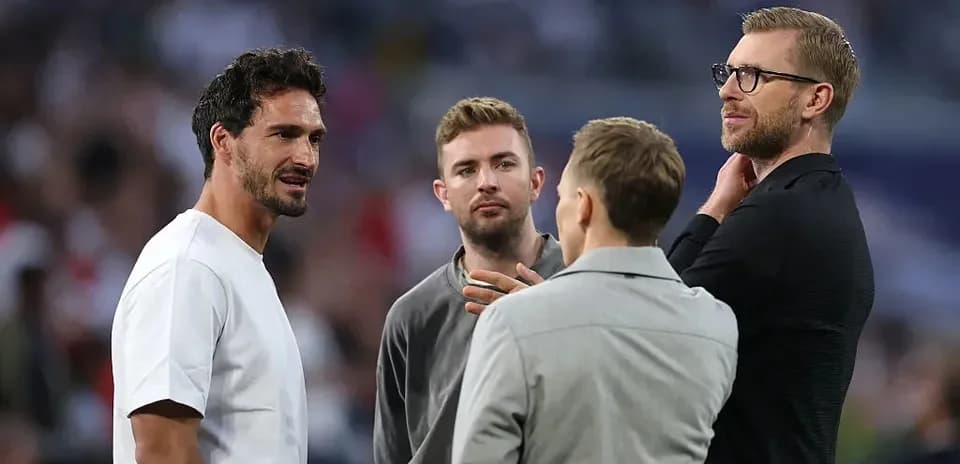 Four men discussing on the sidelines of a match
