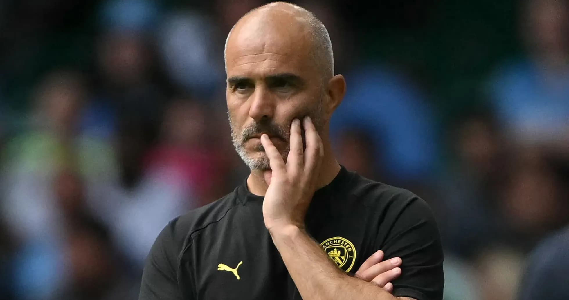 Coach with hand on chin during match observation