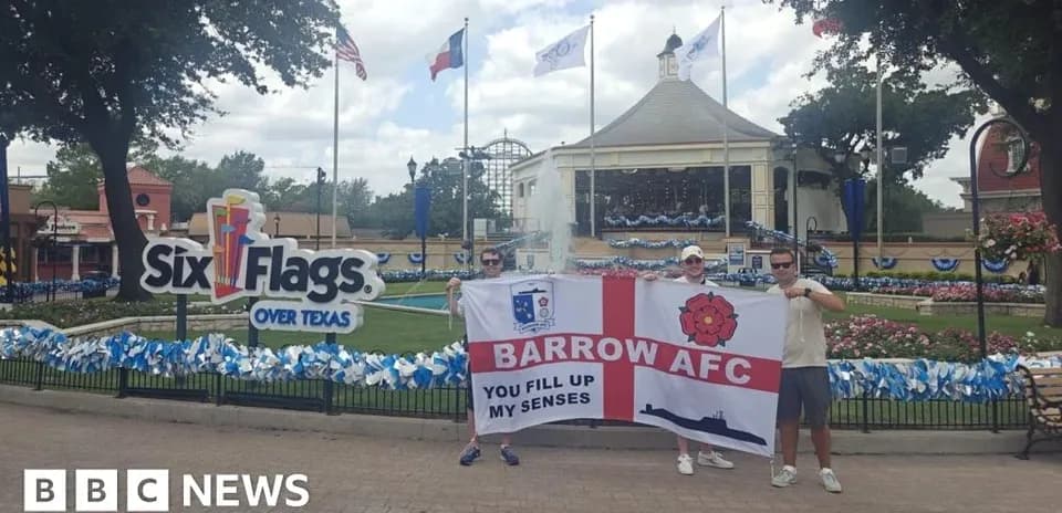 Two fans holding Barrow AFC flag at Six Flags