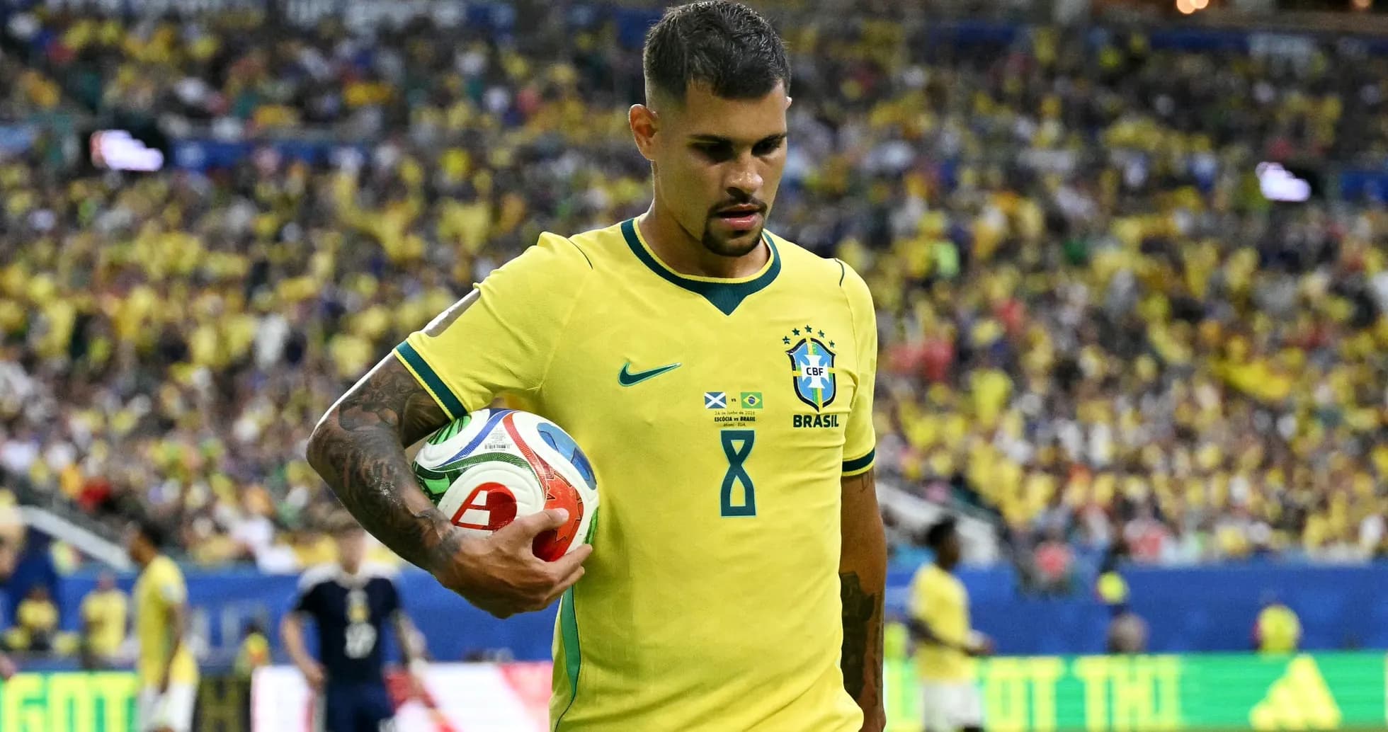 Player in Brazil jersey holding a soccer ball