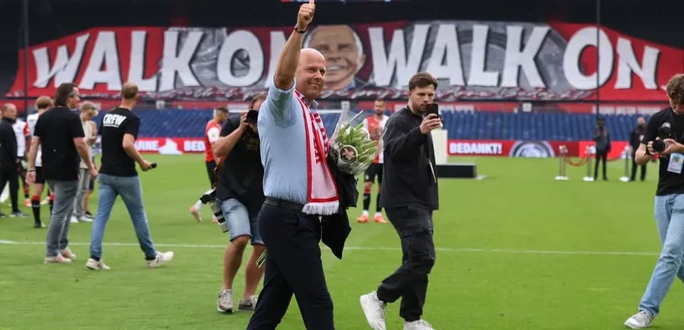 Man waving with flowers on the pitch after match