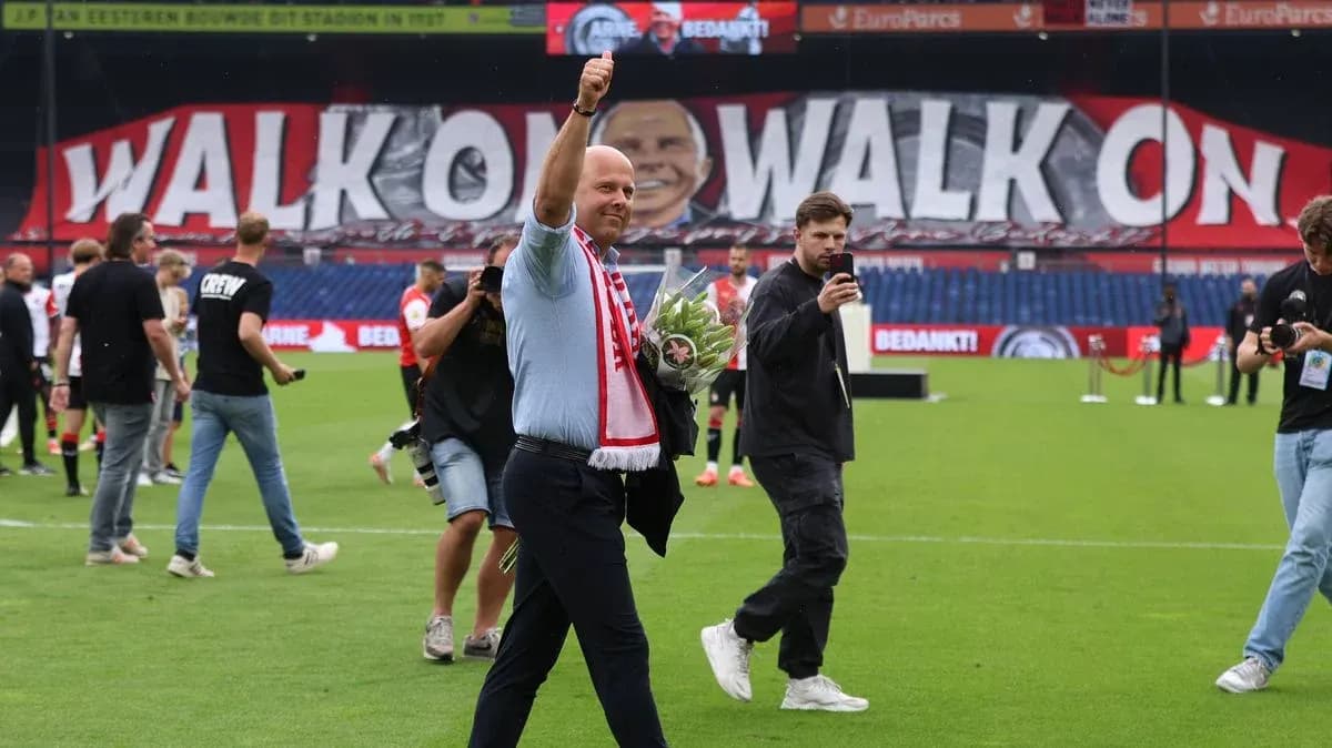 Man waving with flowers on the pitch after match