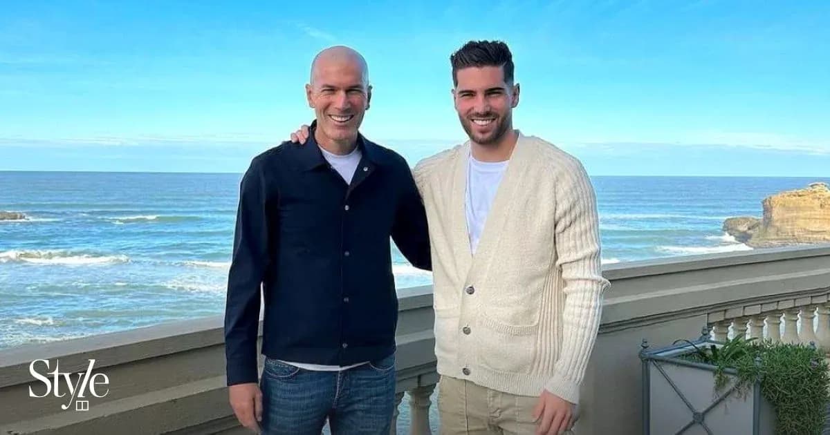 Two men posing together by the ocean