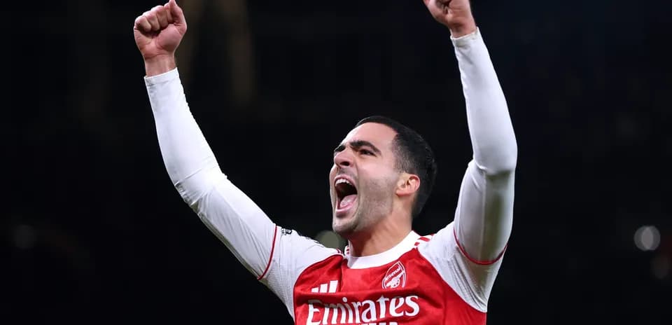 Player celebrating with raised fists in Arsenal jersey