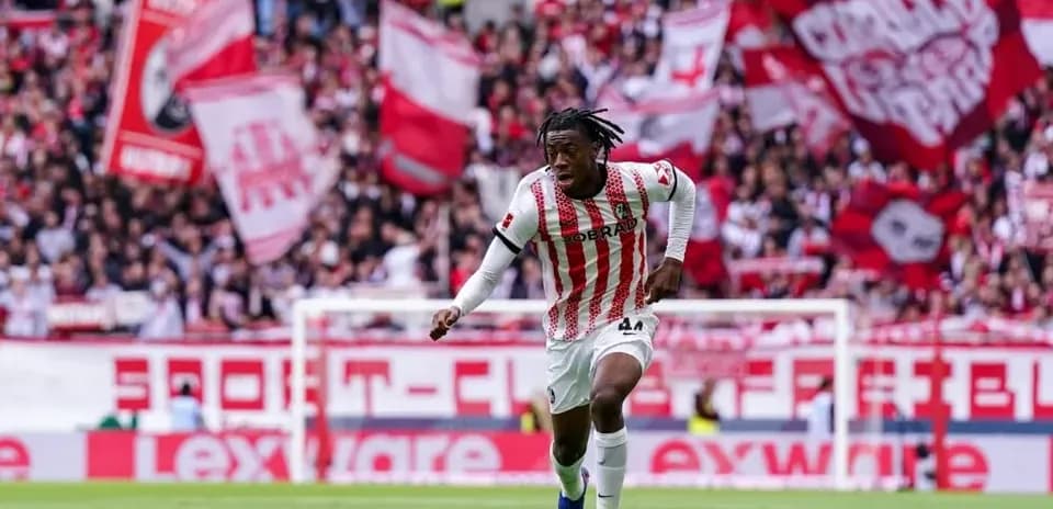 Player running with ball in front of cheering crowd