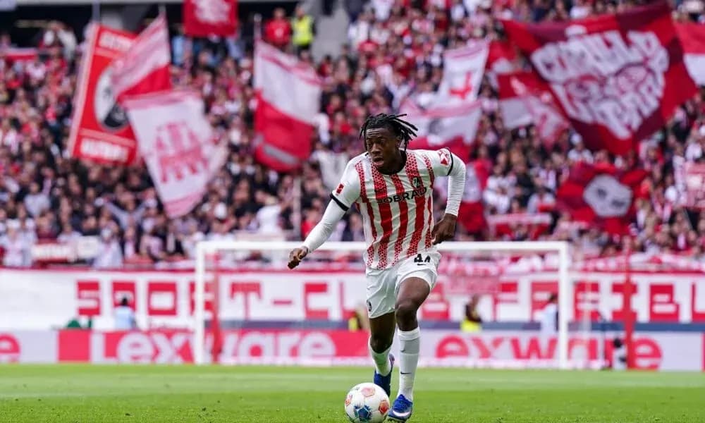 Player running with ball in front of cheering crowd