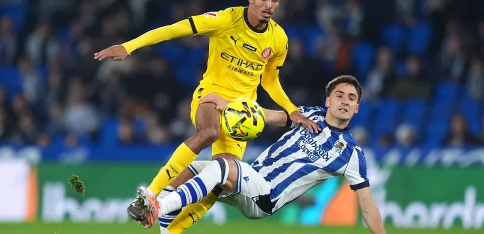Girona player competing for the ball against Real Sociedad