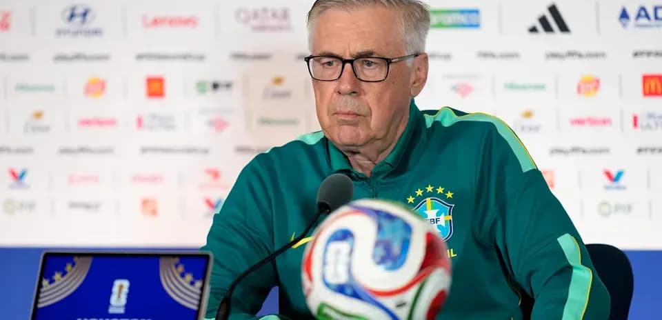 Coach at press conference with soccer ball in foreground