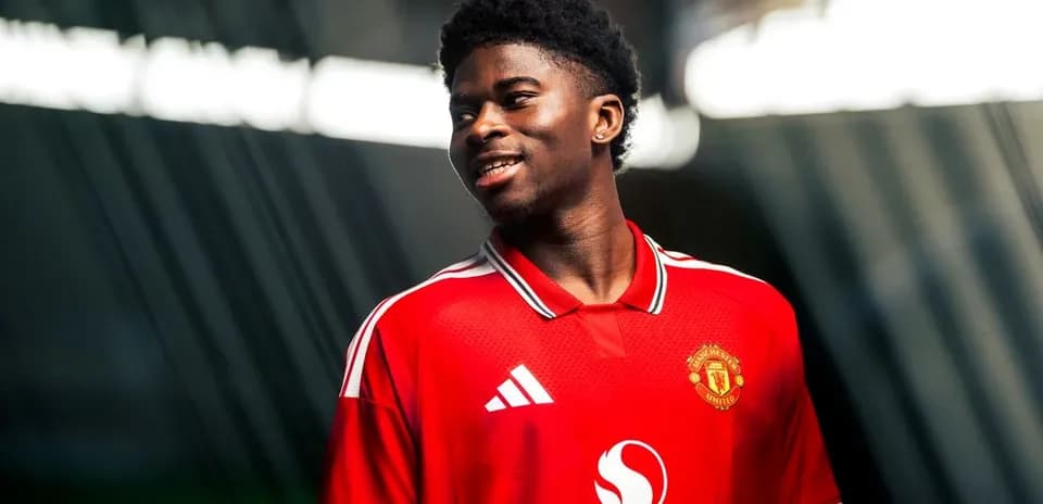 Player wearing Manchester United jersey, smiling