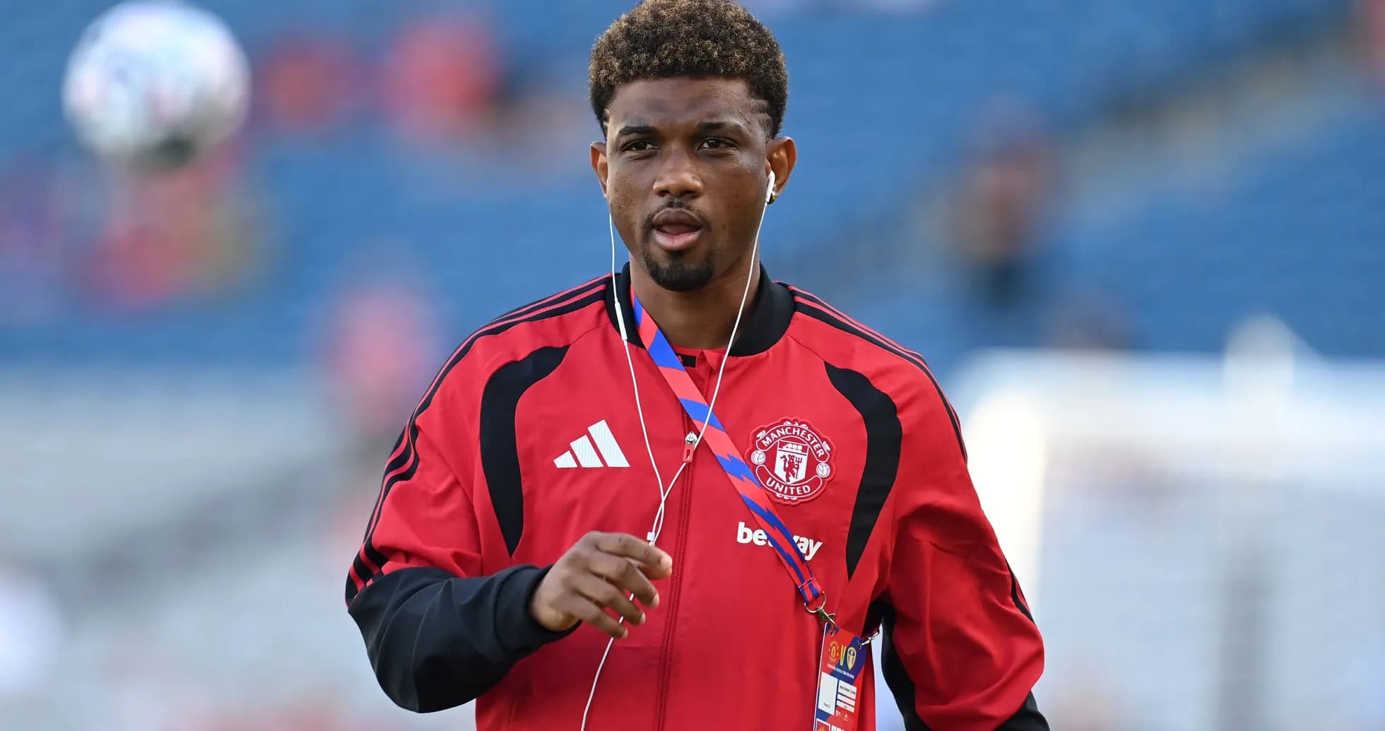 Player walking on pitch in Manchester United tracksuit