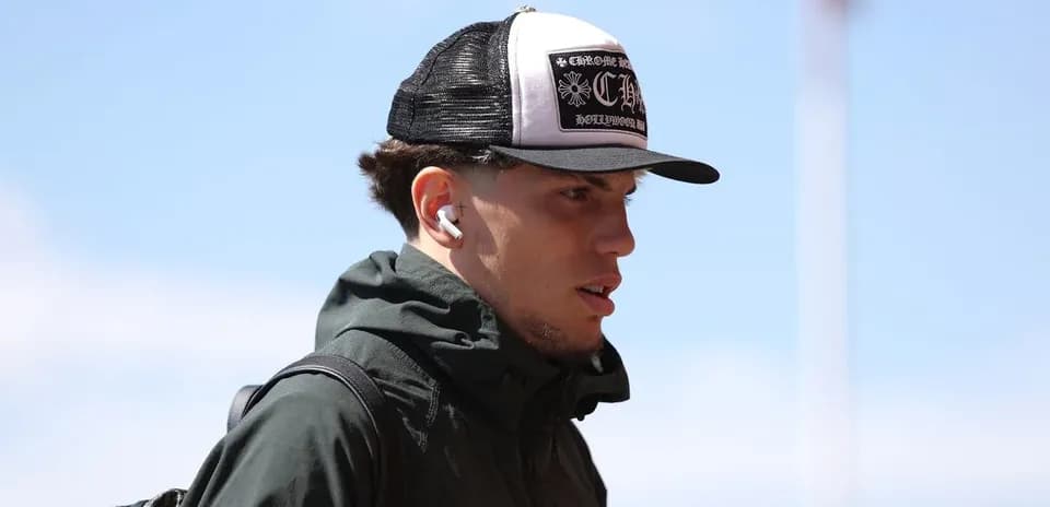 Player wearing a hat and earbuds walking outdoors