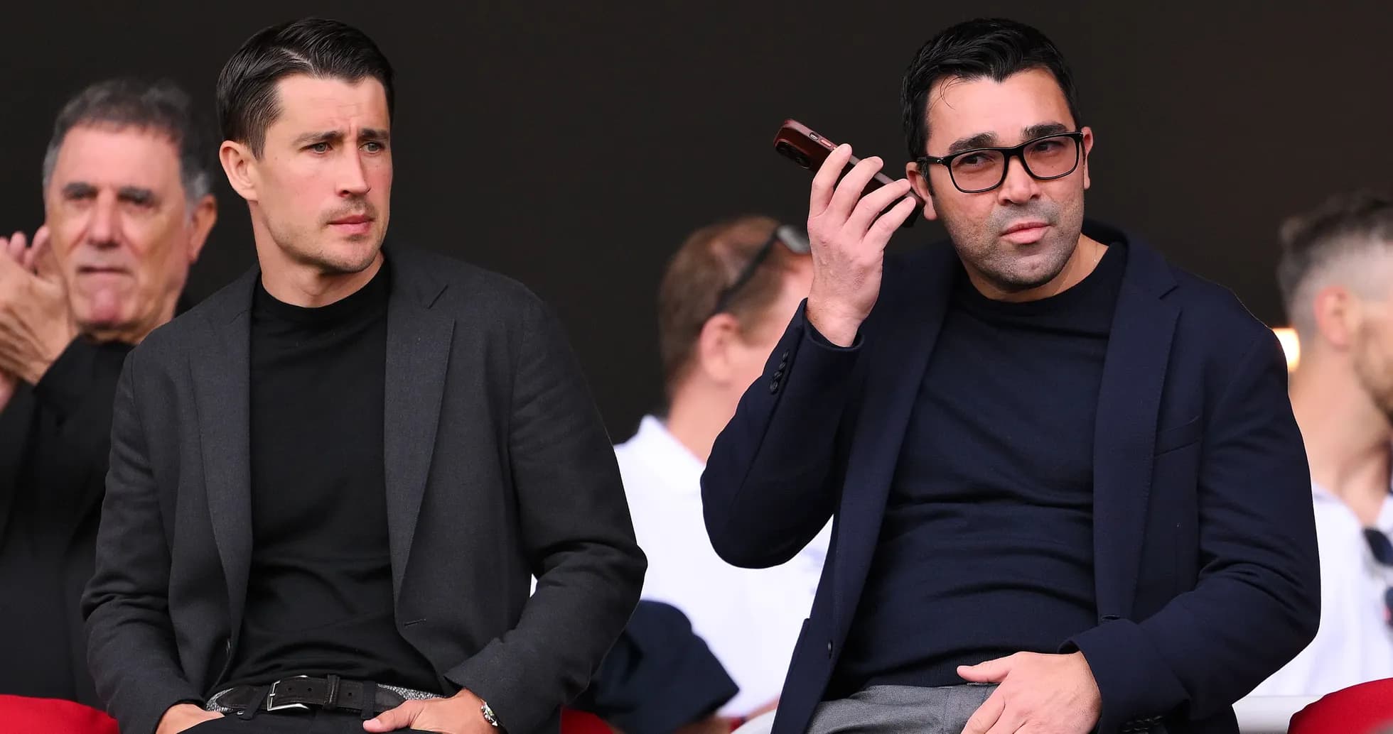 Two men sitting in stands at sports event