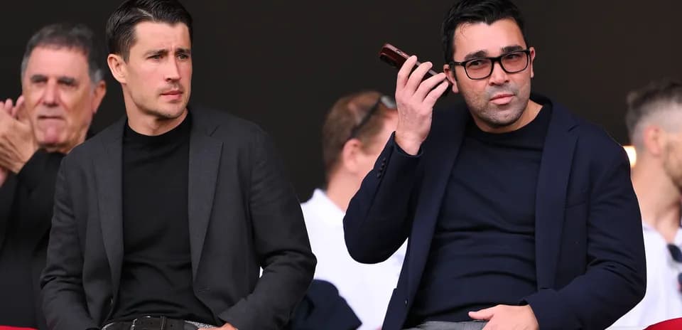 Two men sitting in stands at sports event