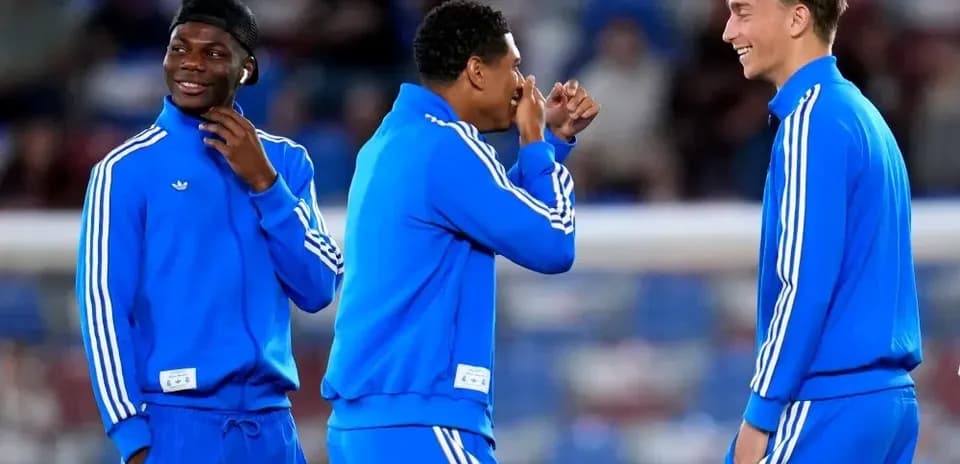 Three players in blue training gear laughing together