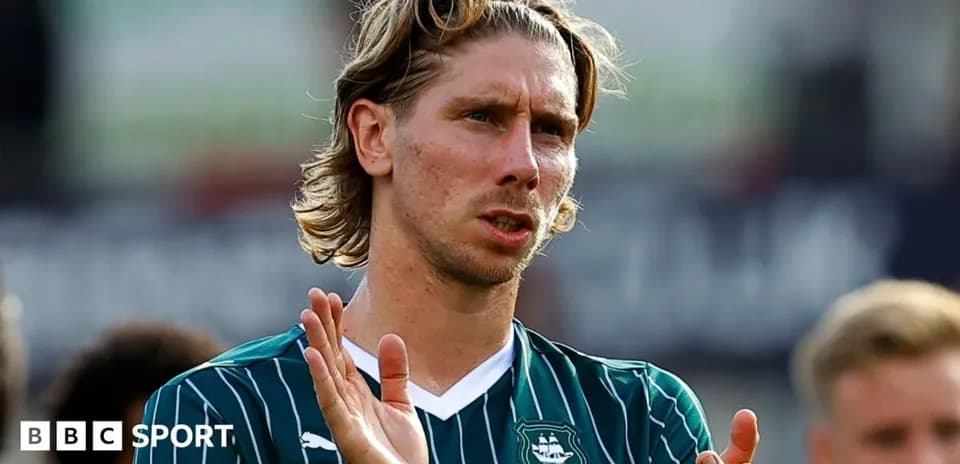 Player applauding fans after match wearing team jersey