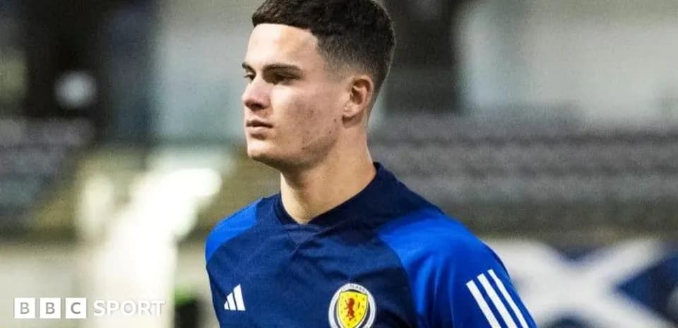 Player in Scotland training kit walking on pitch