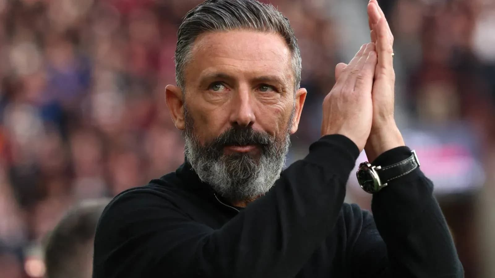 Manager applauding fans during a match