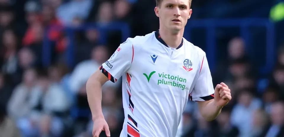Player in white kit running on the pitch