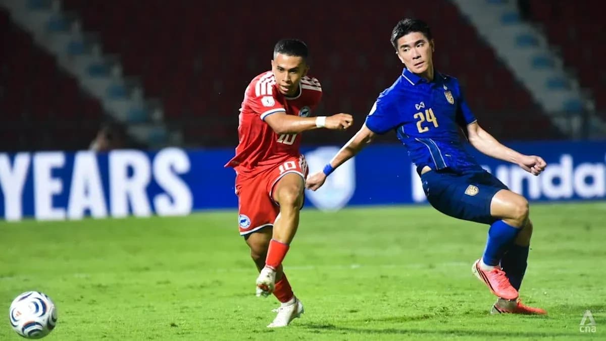 Player in red dribbling past defender in blue jersey