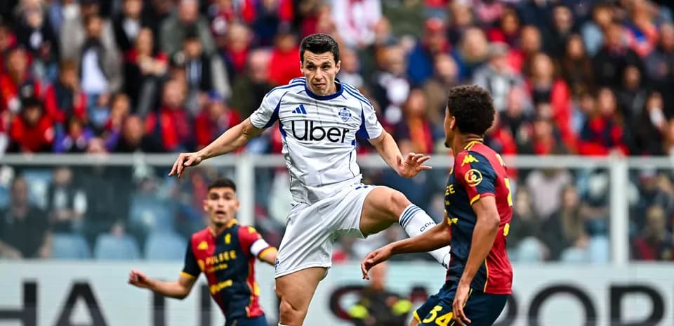 Genoa player challenging Como player for the ball