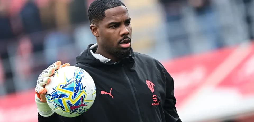 Goalkeeper holding a colorful soccer ball on field