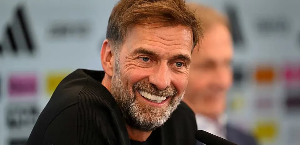 Manager smiling at press conference podium