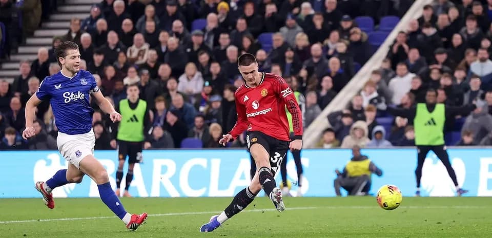 Everton player challenging Manchester United forward