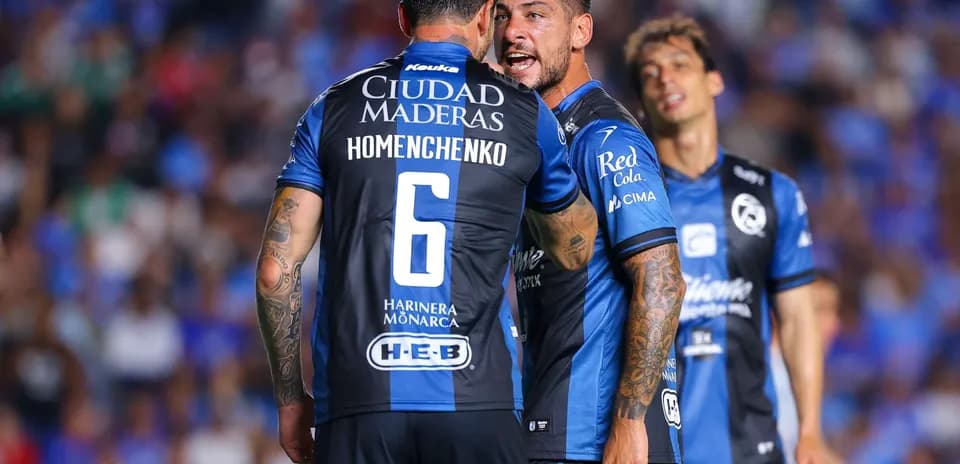 Players discussing strategy during Liga MX match