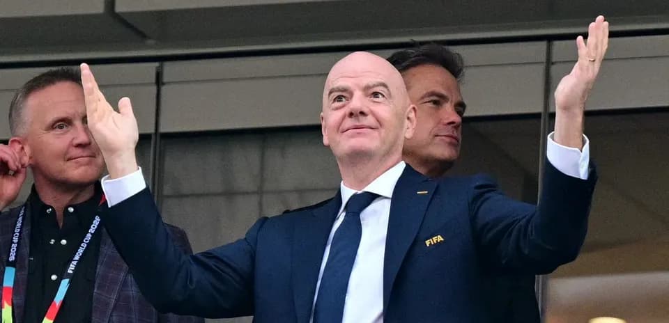 FIFA official gesturing from a VIP box
