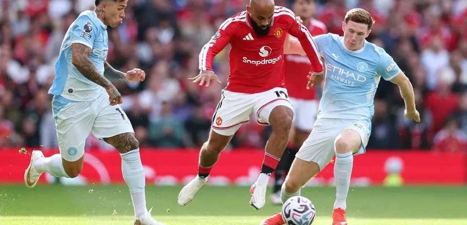 Players from Manchester United and Manchester City competing for the ball