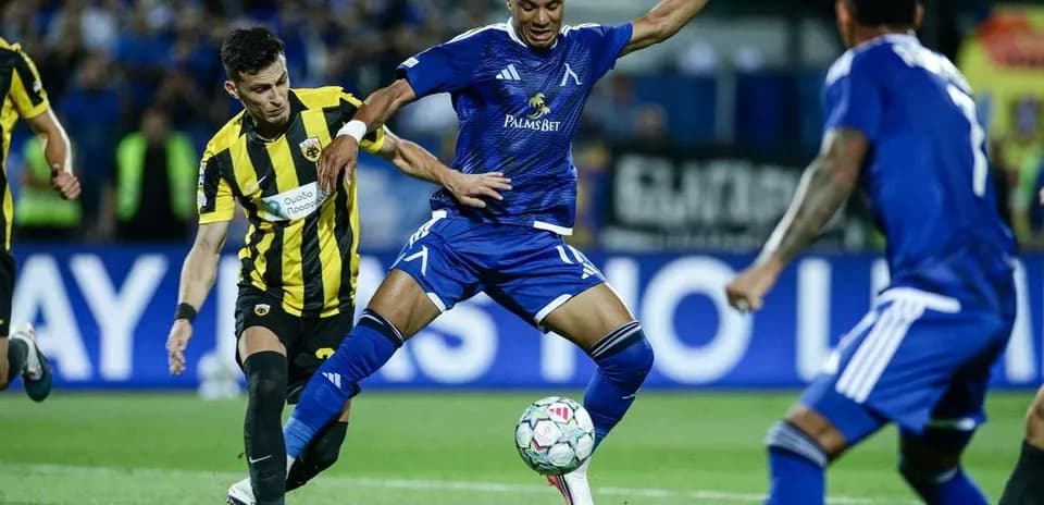 Levski Sofia player dribbling past AEK Athens defenders