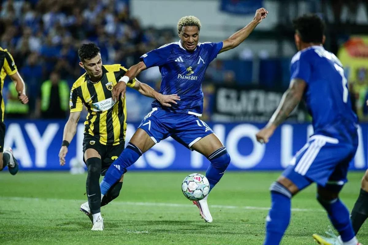 Levski Sofia player dribbling past AEK Athens defenders