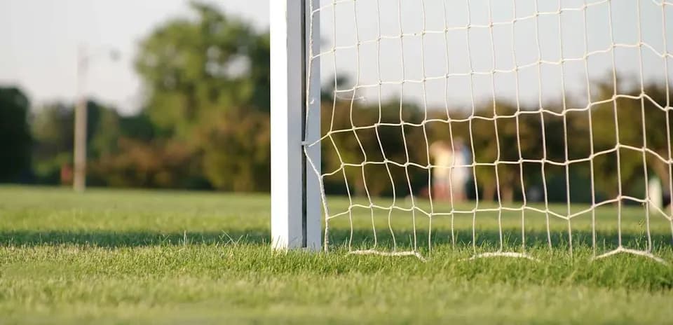Close-up of soccer goalpost and net on field