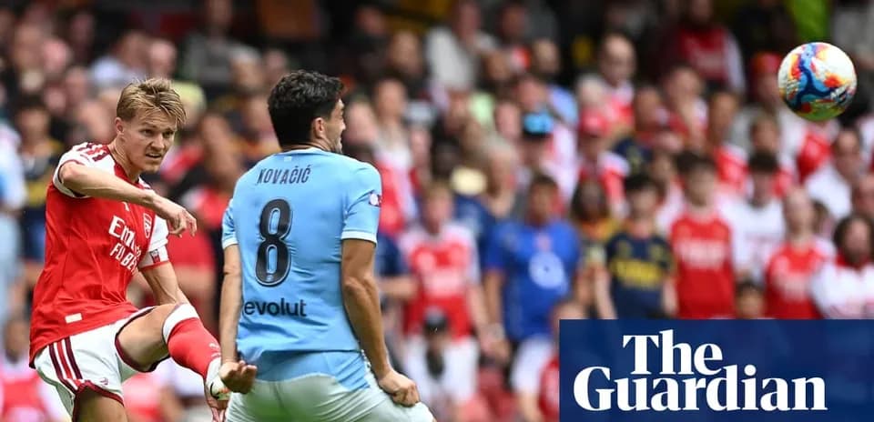 Arsenal player kicking ball towards opponent during match