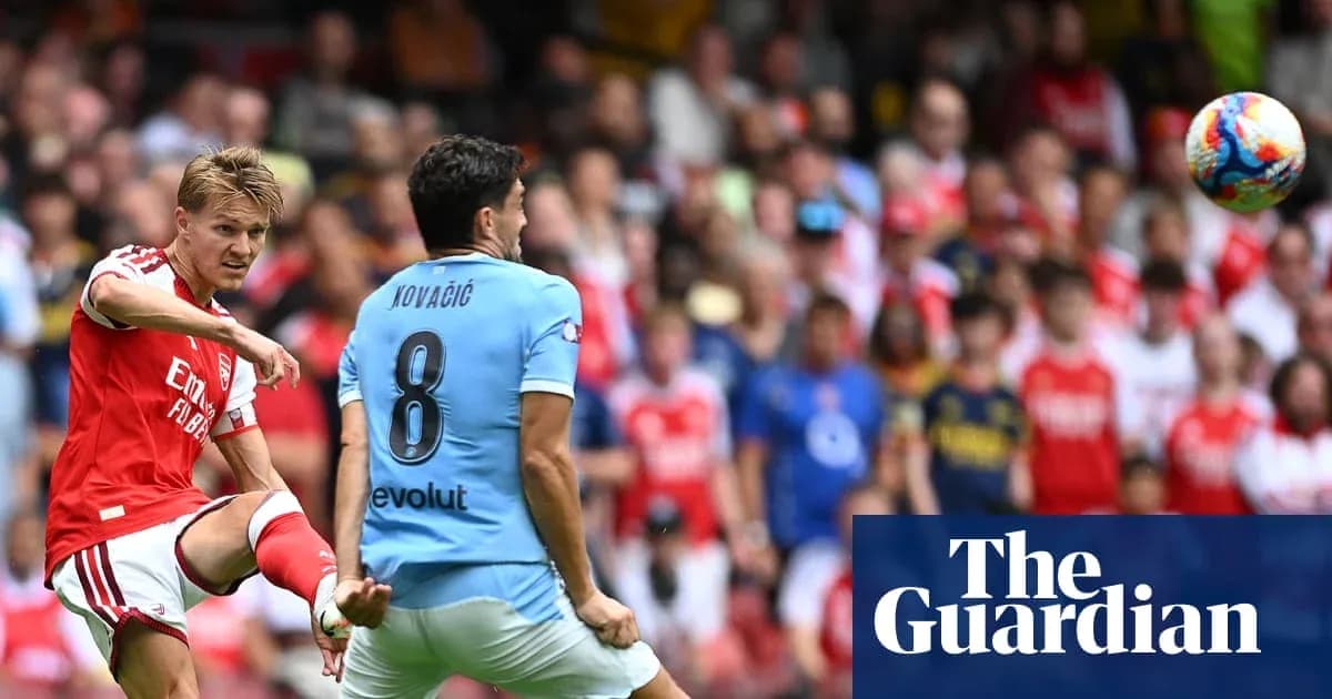 Arsenal player kicking ball towards opponent during match