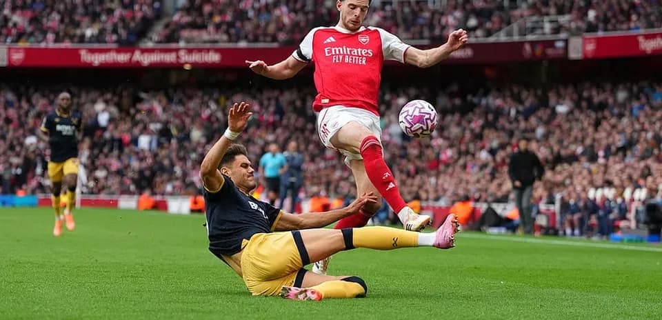 Arsenal player evading a tackle during match
