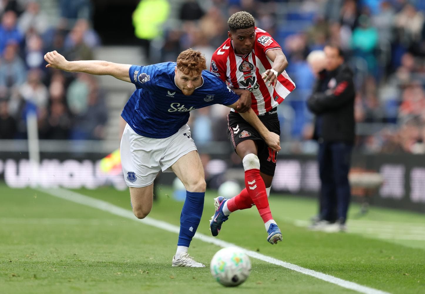 Everton player tackling Sunderland opponent during match