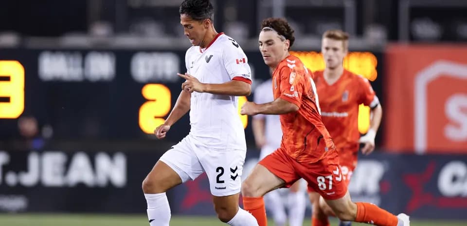 Vancouver FC player dribbling past Forge FC opponent