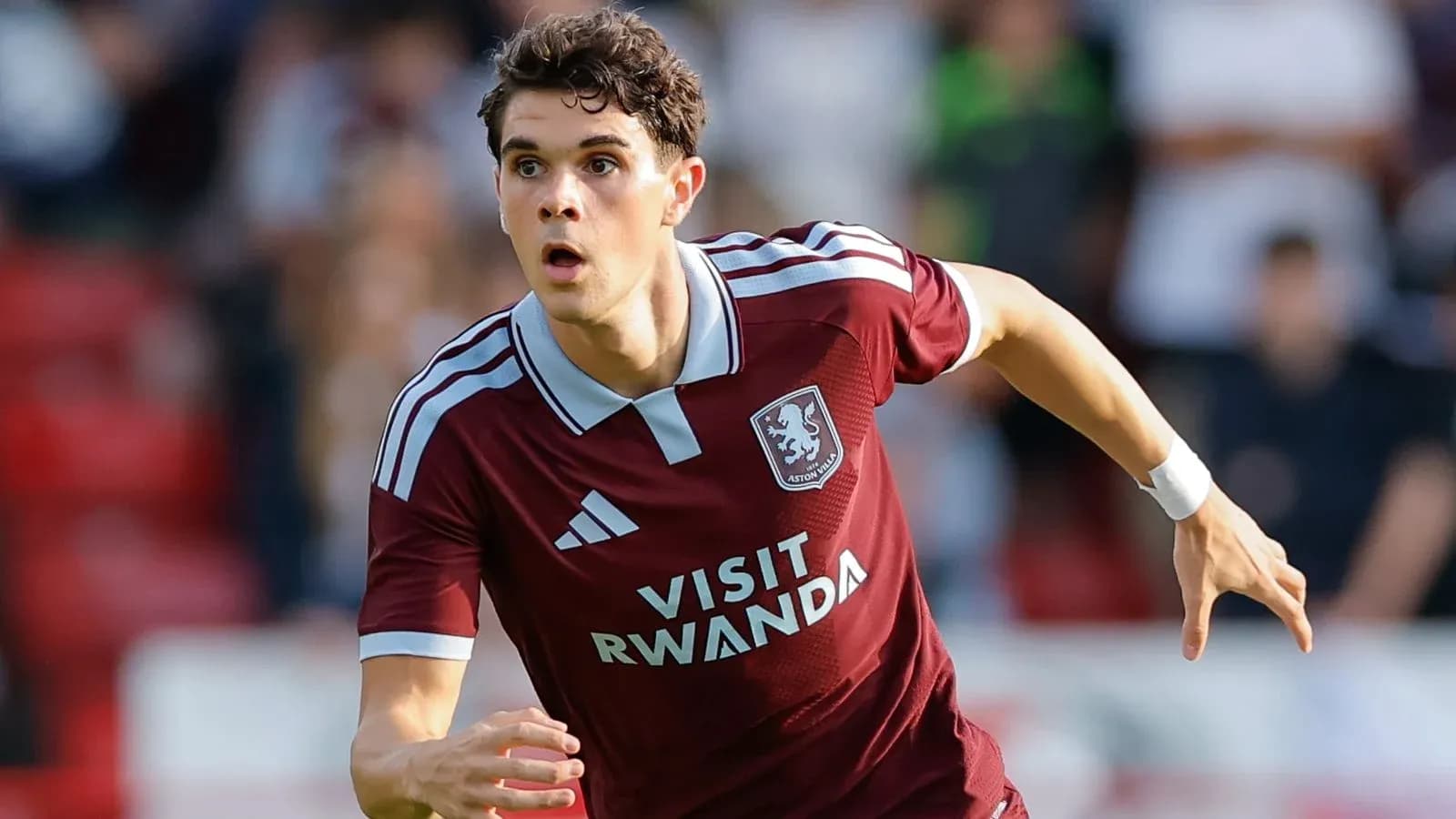 Player running during a football match in maroon kit