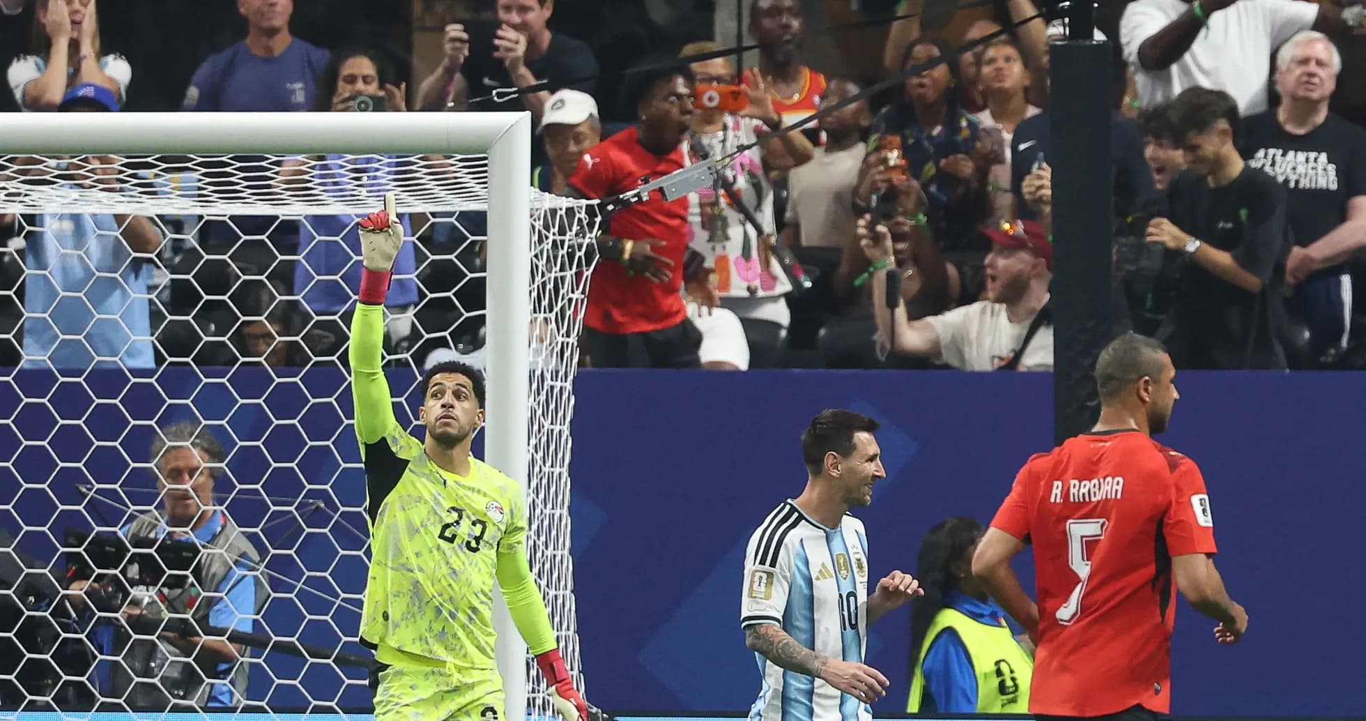 Goalkeeper celebrating while Messi and opponent react