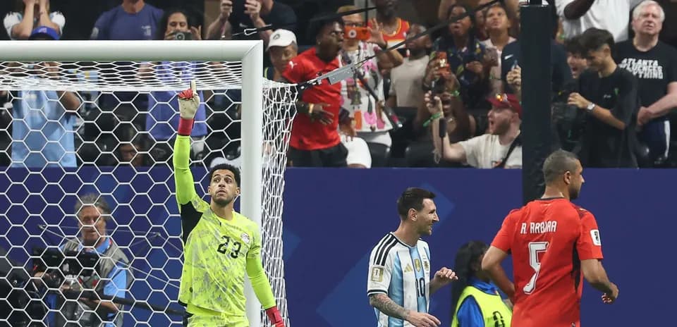 Goalkeeper celebrating while Messi and opponent react