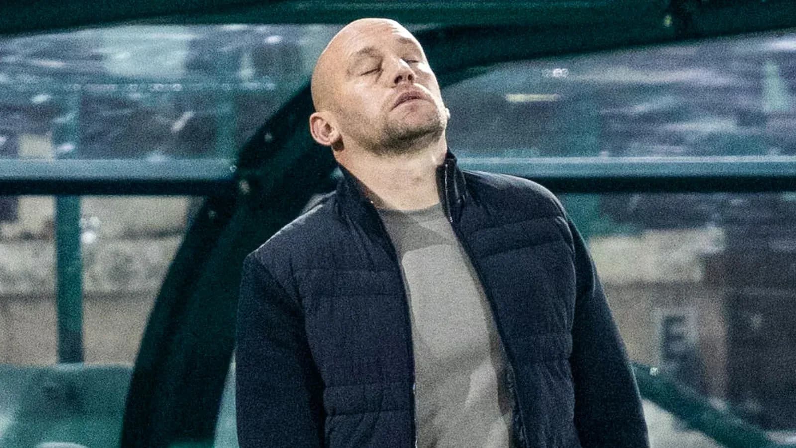 Coach with eyes closed on the sidelines