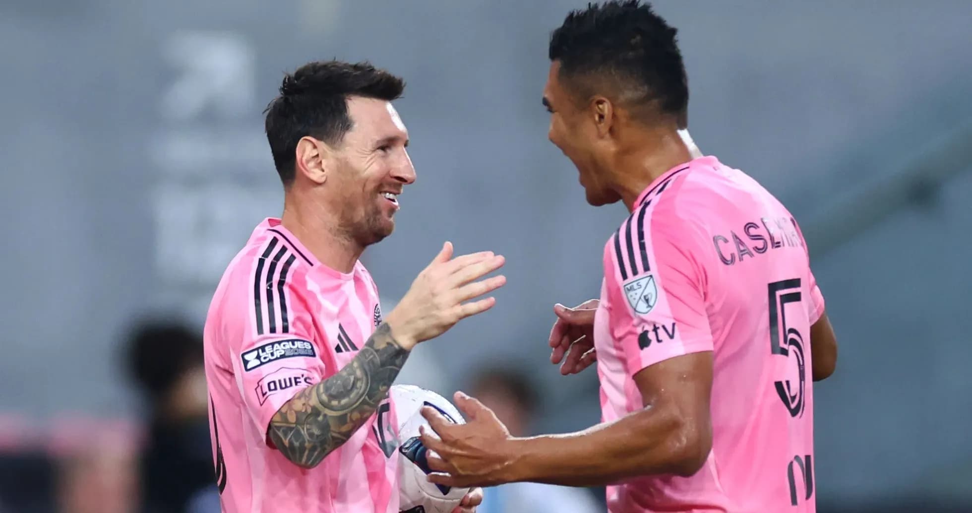 Players celebrating a goal in pink jerseys