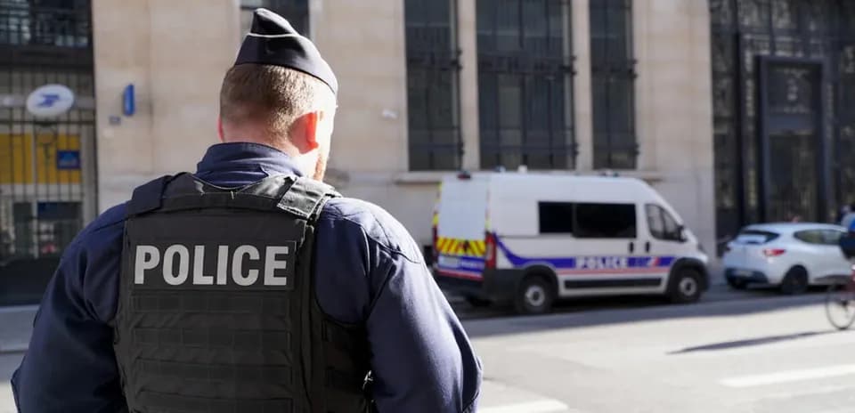 Police officer observing scene near police van