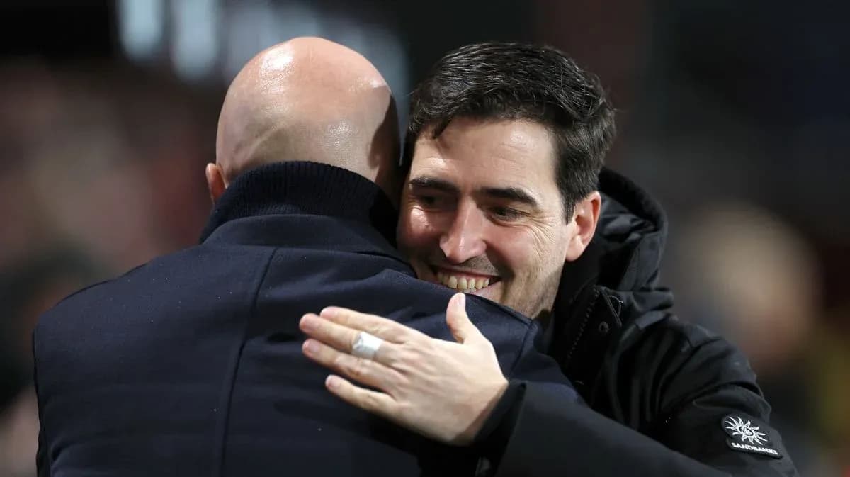Two coaches embracing on the sidelines