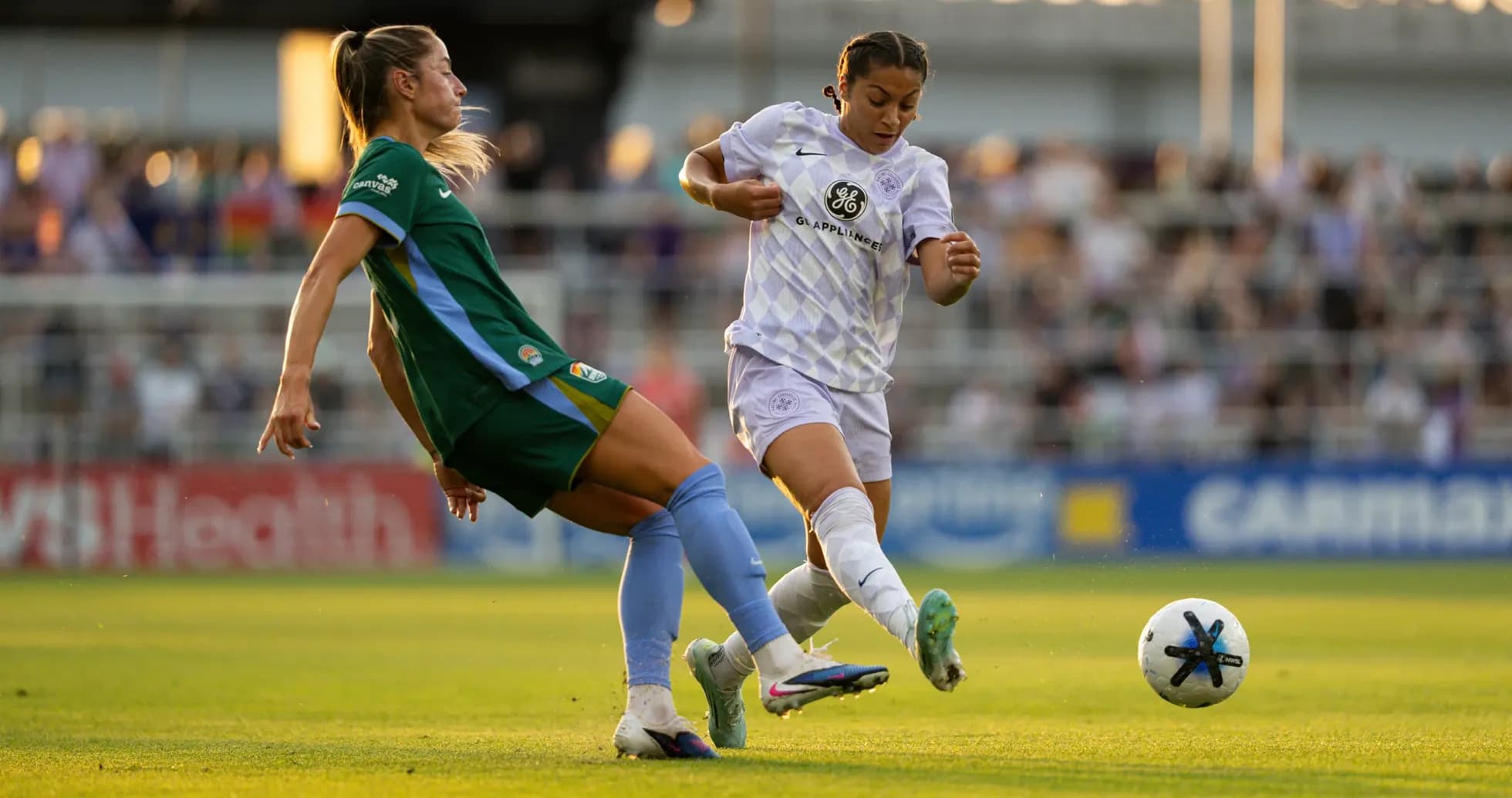 Two players contesting the ball in NWSL match