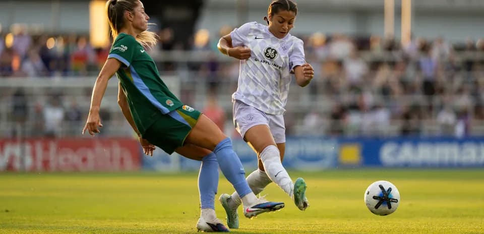 Two players contesting the ball in NWSL match