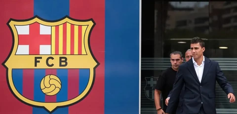 Player leaving Barcelona headquarters next to club logo