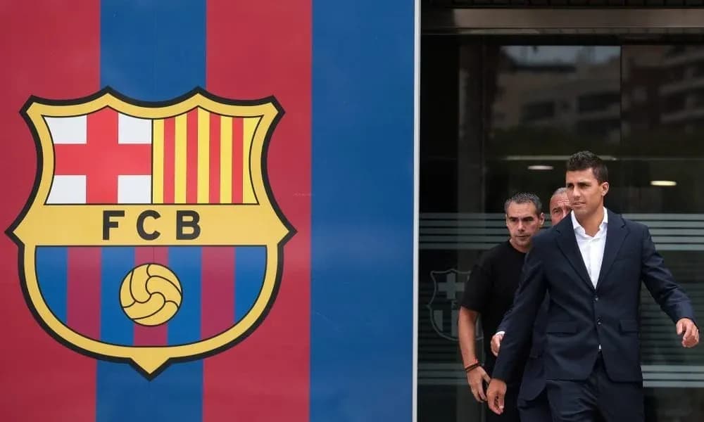 Player leaving Barcelona headquarters next to club logo