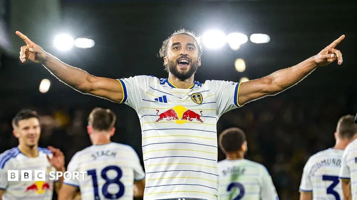 Player celebrating a goal with teammates in stadium